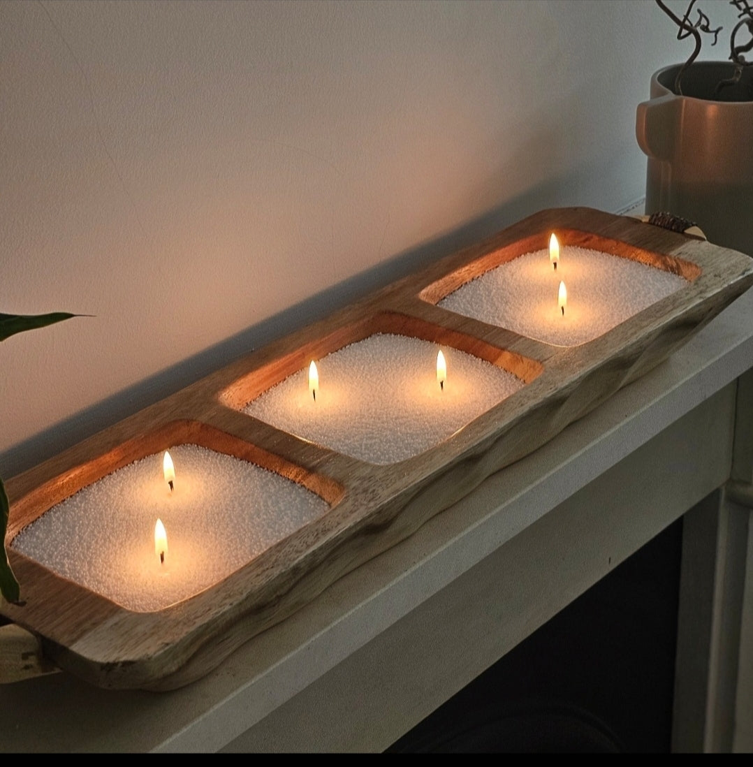 White candle sand and multiple wicks arranged in a three-section wooden dough bowl for modern table decor.
